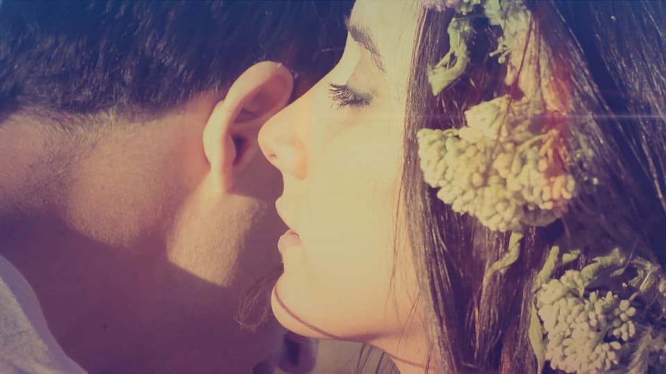 A photo of a woman whispering into a man’s ear