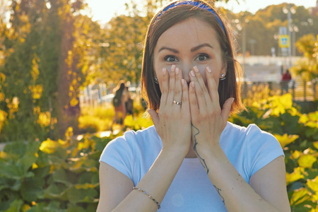 An image of a surprised girl covering her mouth. 